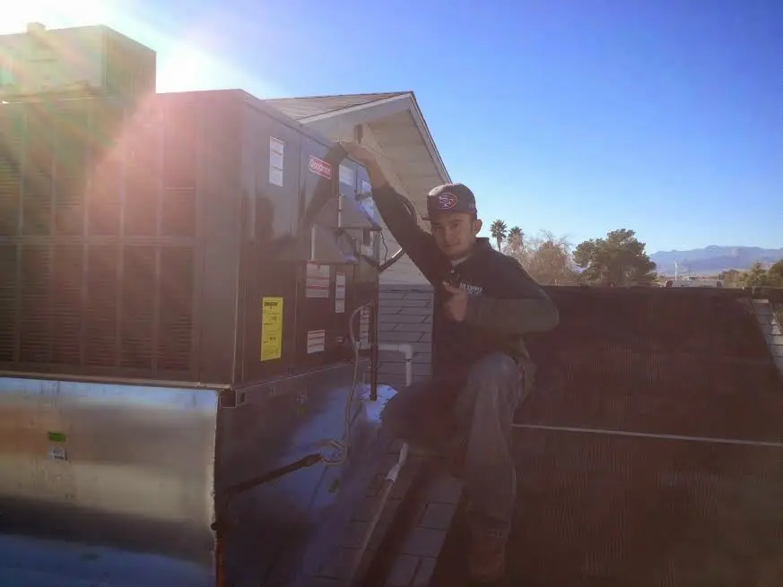 HVAC technician performing Heat Pump Repair on a rooftop unit in Griffin